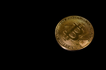 Golden bitcoin on black background. Cryptocurrency symbol on black bacground, top view with copy space. Digital cryptocurrency.