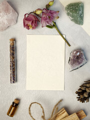 Blank paper card with flower, crystal stones and nature object around. Stationery mockup.