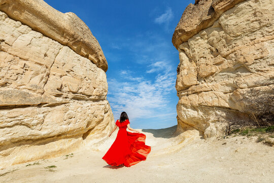Girl in a red dress near the caves in Cappadocia