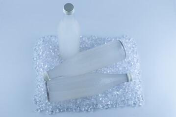 Obraz na płótnie Canvas A white bottle with a soda drink on ice isolated.