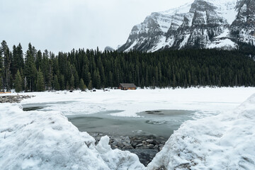 Cabin on Lake Louise, Banff National Park with the frozen lake and snow capped mountains