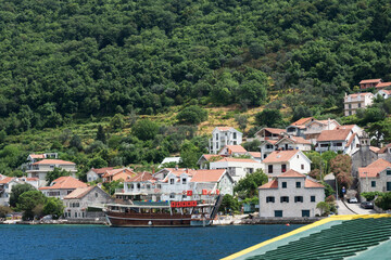 Fototapeta na wymiar Ferry crossing Kamenari-Lepetani Montenegro in the Bay of Kotor. View of the mountains, houses from the ferry. Travel Montenegro.