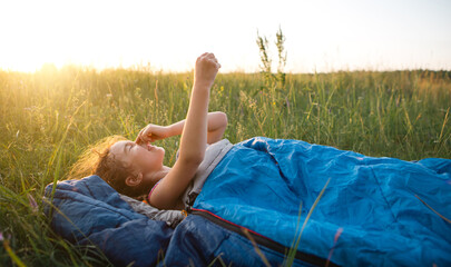 The girl is dissatisfied with scratching mosquito bites, child sleeps in a sleeping bag on the...