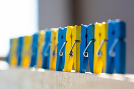colorful clothespin yellow and blue background in the colors of the Ukrainian  flag - abstract vision people and residents