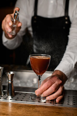 close-up of hand neatly holding glass with a drink and sprinkles on it