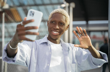 Authentic portrait of smiling successful influencer using mobile phone communication online with...