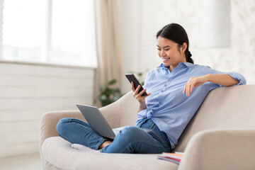 Obraz premium Cheerful korean lady freelancer working from home