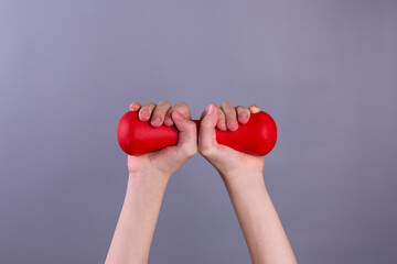 Girl 's hands holding red dumbbell on grey background. concept.  Sport and healthy lifestyle concept with Copy space.