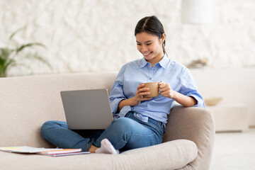 Relaxed japanese woman watching movie online, using laptop