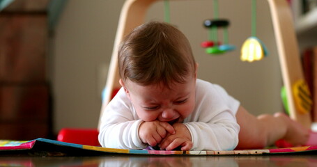 Adorable baby infant child on play mat floor, cute one year old child