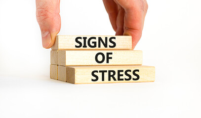 Signs of stress symbol. Concept words Signs of stress on wooden blocks. Beautiful white table white background. Doctor hand. Psychological business and signs of stress concept. Copy space.