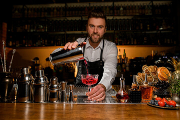 magnificent view of the bar counter with a variety of bar equipment and goblet in which bartender...