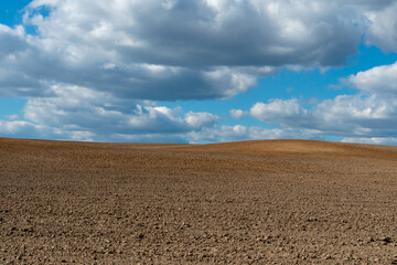 Rows of soil before planting. Drawing of furrows on a plowed field prepared for spring sowing of agricultural crops. View of the land prepared for planting and growing crops.