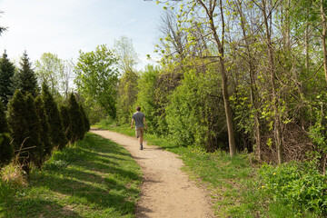 Fototapeta premium Man, in shorts, walks along the path on a warm spring day
