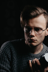 portrait of a young handsome man with glasses in a dark studio