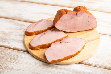 Smoked pork ham on white wooden background. Side view, close up.