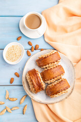 Traditional armenian dessert gata with cup of coffee on a blue wooden background. top view, close up.