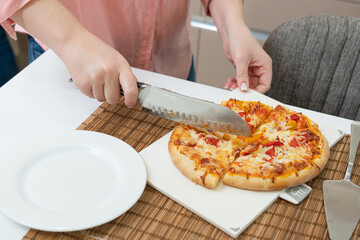 separating slices of pizza on the table for dinner