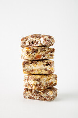fitness bars from cereals, nuts, dried fruits stand in a stack on a white background