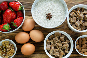 Ingredients for fruit strawberry crumble on rustic wooden table, close up, top view. 
