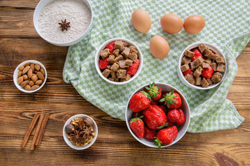 Strawberry summer dessert with ingredients on rustic table, top view. 