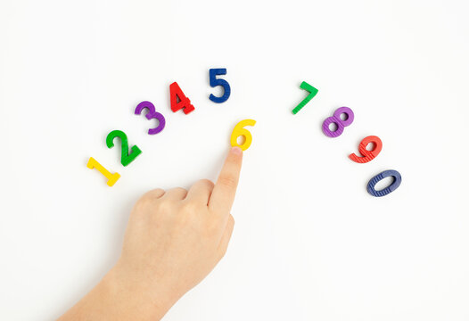 The child uses his index finger to move the number six up. Early education. We learn colors and count from zero to ten