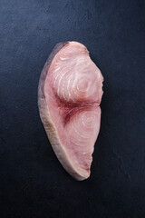 Raw swordfish steak offered as top view on a black board with copy space