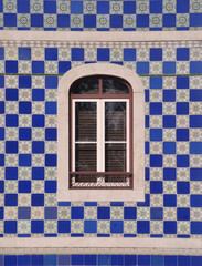 Janela de um edifício típico português com azulejos em redor, mistura de quadrados com ...