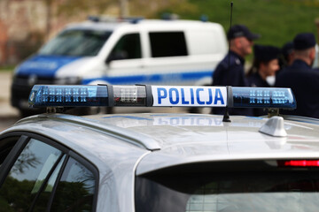 Radiowóz polskiej policji w mieście podczas patrolu.  - obrazy, fototapety, plakaty