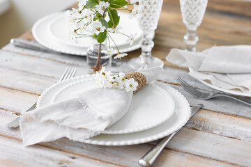 Rustic zero waste wedding decor with natural elements. Wooden table, candles, linen napkins, branches with green leaves. Eco-friendly decoration for the special dinner. Romantic and cozy place