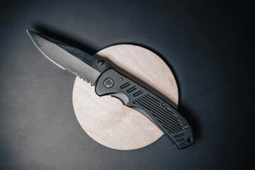 Close up detail photo of a combat folding knife. Product design photo of an army or SWAT knife. Sharp concealed carry knife. Every day carry knife on black background. - obrazy, fototapety, plakaty