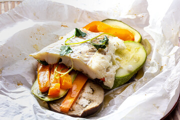 White fish fillet with vegetables in rustic style. Healthy eating: cooked fish fillet with...