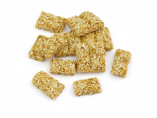 Sesame roasting on a white background. Candy from sesame seeds close-up. White toasted sesame seeds in caramel, fresh  kozinaki