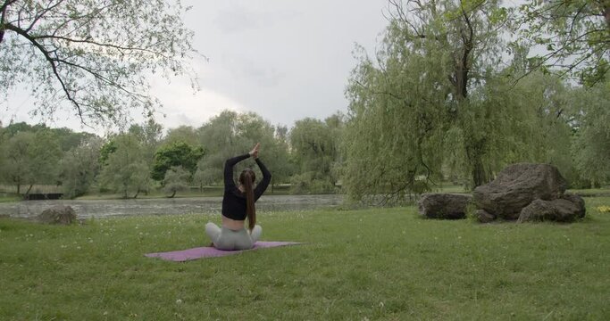 Young beautiful girl having yoga practicing outdoors.