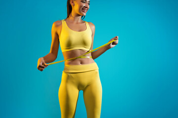 Woman Measuring Waist After Weight Loss, Blue Background, Cropped