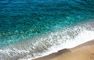 Top view of the turquoise sea surrounded by a deserted beach