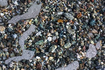 Top view of one little blonde child playing on the seashore with waves