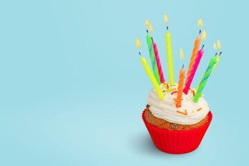 Celebration birthday cupcake with birthday candle and sprinkles on a background