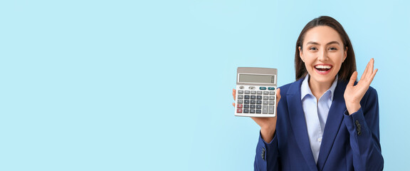Happy young businesswoman holding calculator on light blue background with space for text - obrazy, fototapety, plakaty