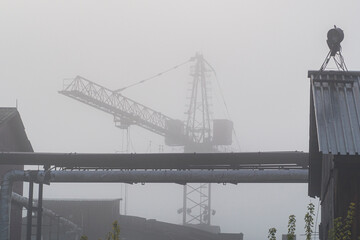 Factory crane in fog