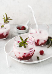 Healthy summer berry drink of raspberry sauce and buttermilk smoothie. Homemade sweet food concept. Selective focus.