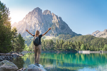 Woman With raised Arms in a majestic Lake in summer. Discovery Travel Destination. Freedom Concept