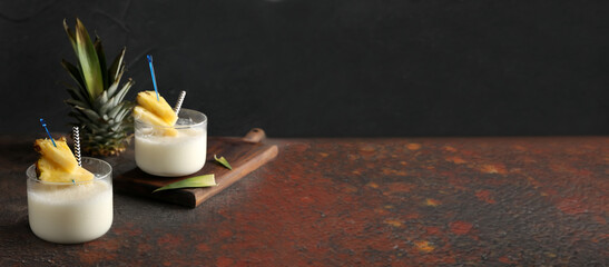 Tasty Pina Colada cocktails on dark background with space for text