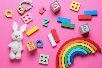 Colorful children toys on pink background