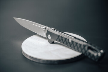 Pocket knife close up detail photo. Foldable sharp pocket knife with plastic or wooden handle. Stainless steel army or special forces knife. Every day carry.