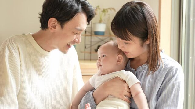 赤ちゃんを見つめる夫婦