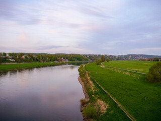 Fototapeta na wymiar Large riverbanks of the Elbe river in Dresden. Green meadows in the Elbe valley. There is a lot of space for the river and the water before being dangerous for the buildings next to it.