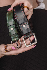 Handmade belts in the hands of a girl