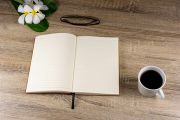 Top view of laptop, notebook, glasses, coffee mug on wooden table for concept work from home, To-do list, Business home.