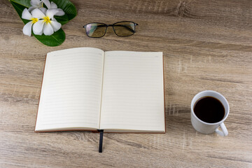 Top view of laptop, notebook, glasses, coffee mug on wooden table for concept work from home, To-do list, Business home.